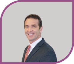 A man in a suit smiling.